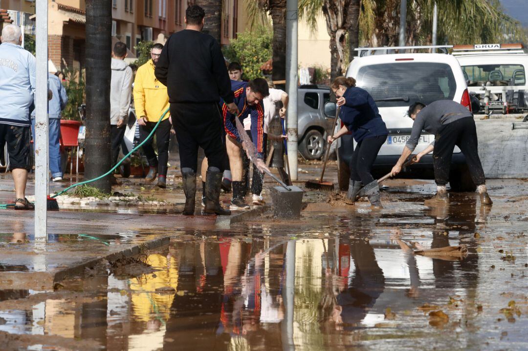 Vecinos de la barriada malagueña de Campanillas, se afanan en las limpiezas de sus hogares y calles del barrio tras la tromba de aguda caída esta pasada madrugada a consecuencia de la Tormenta Gloria que azota al país