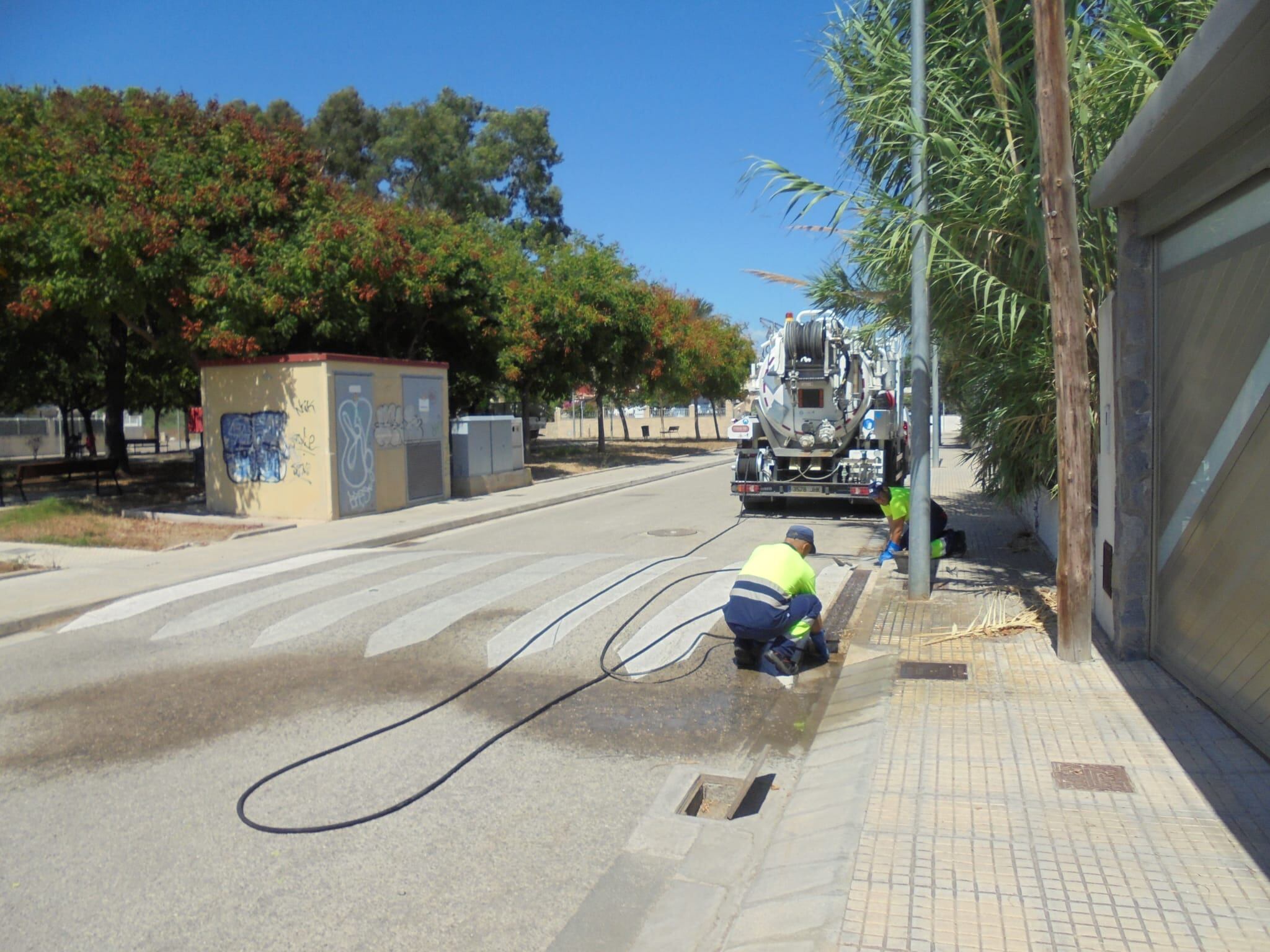 Operarios limpian los desagües de la barriada de Kentuky en Gandia.