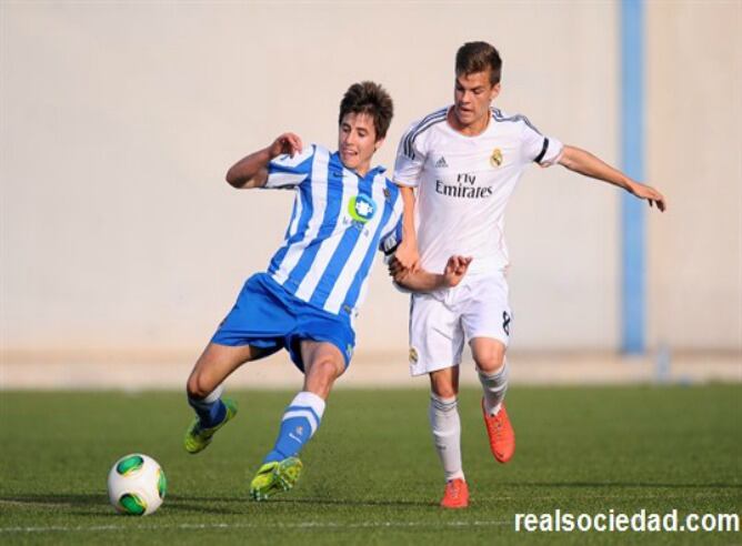 El realista Imanol Sarriegi protege el balón ante la oposición de un rival del Madrid.