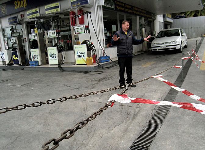 Un operario de una gasolinera cerrada por la huelga gesticula ante un cliente.
