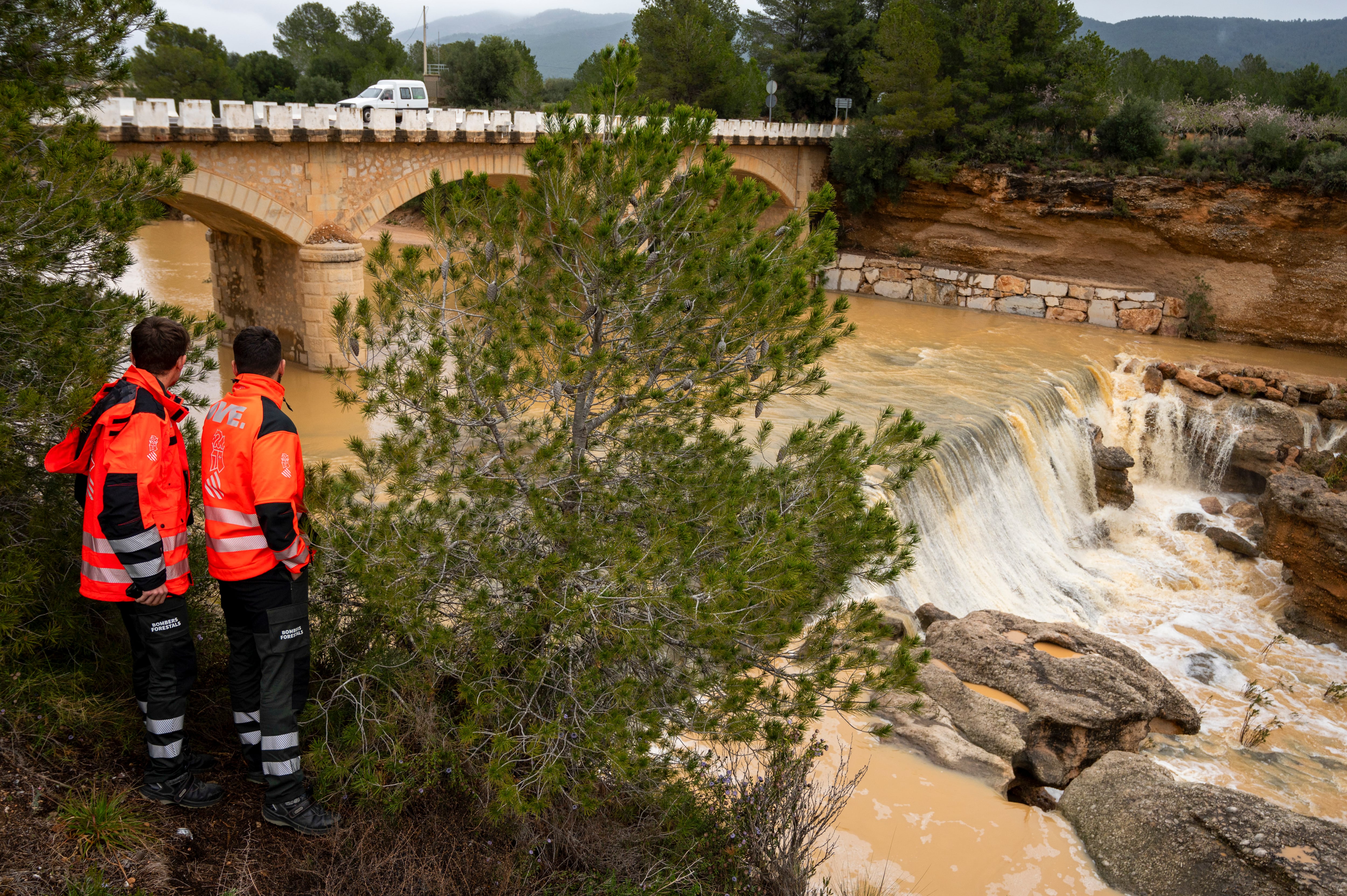 GRAFCVA5979. ELS IBARSOS (CASTELLÓN), 04/03/2025.- Una pareja de bomberos forestales de la Generalitat vigila el caudal de la Rambla de la Viuda en Els Ibarsos (Castellón) afectada por el temporal de lluvias que afecta a la Comunitat Valenciana. EFE/Andreu Esteban
