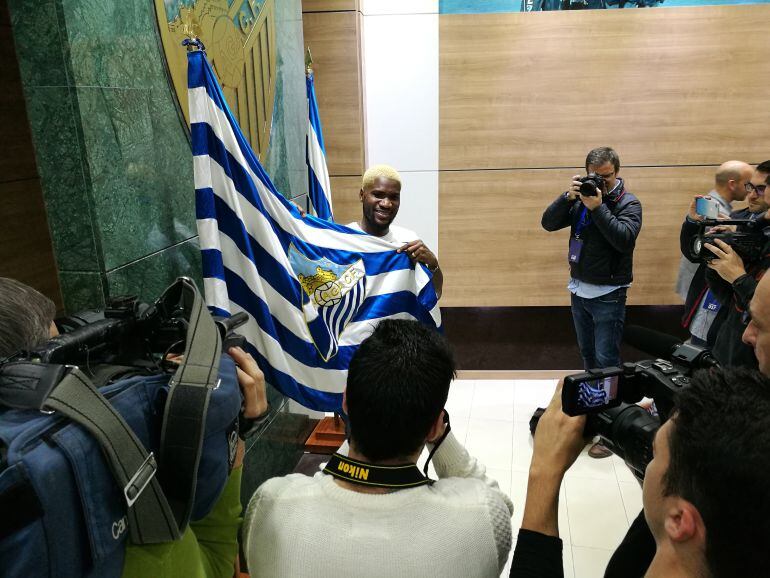 Brown Ideye, posando para los redactores gráficos con la bandera del Málaga