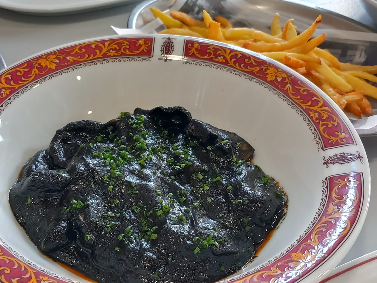 Choco guisado en su tinta con papas fritas