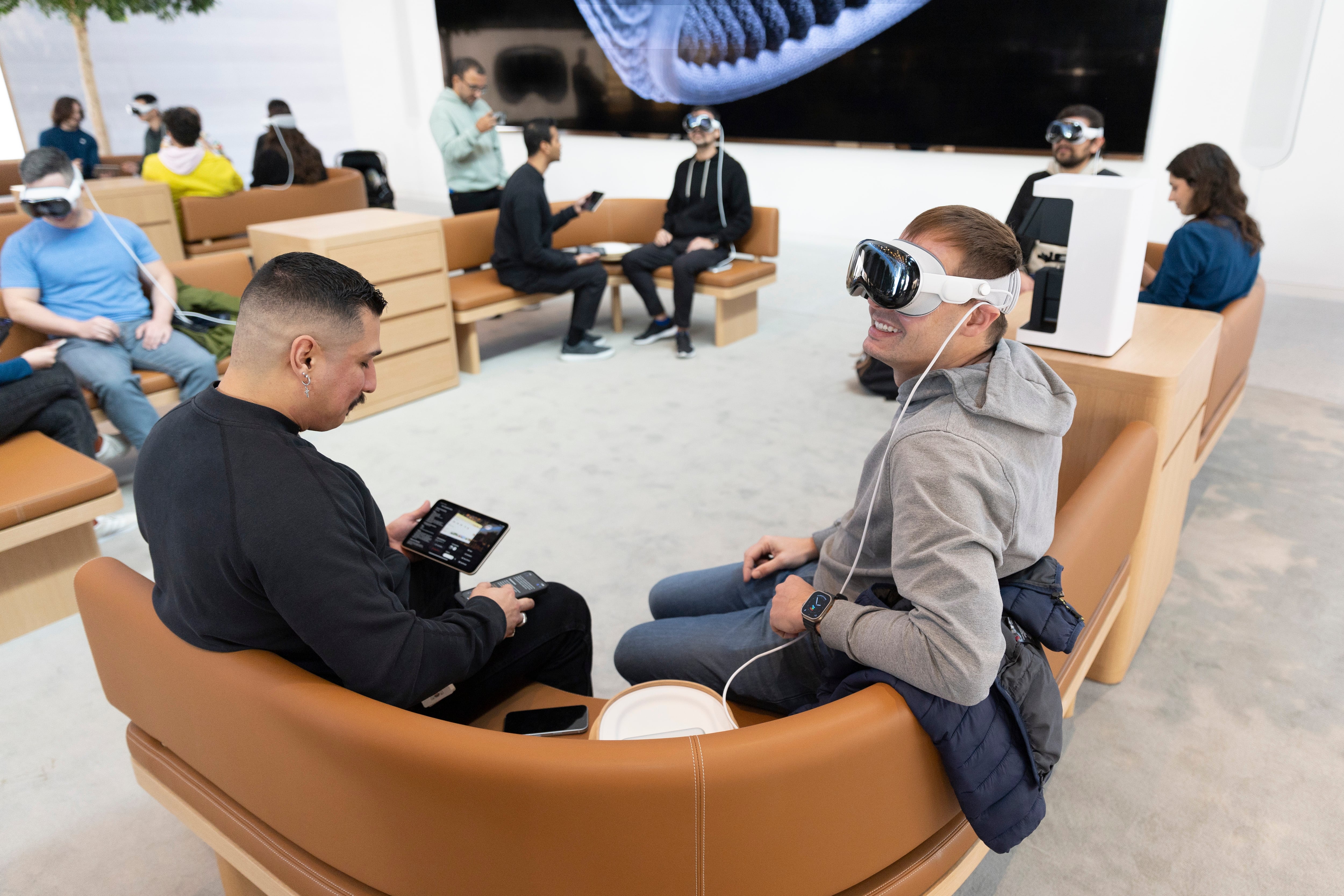 Customers try on the Apple Vision Pro headset in a Apple Store at The Grove during the new device&#039;s launch in Los Angeles, California, USA.