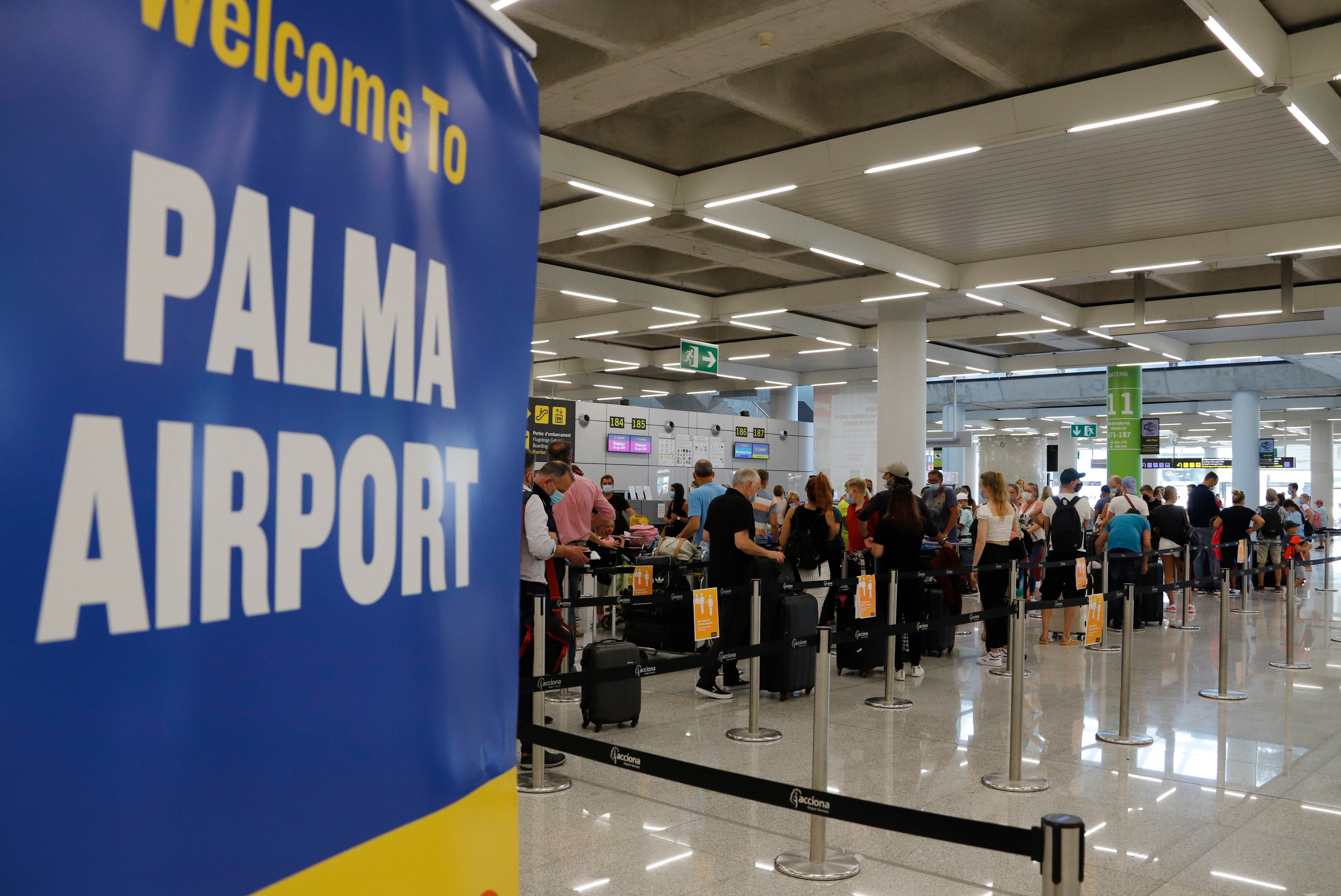 MALLORCA, SPAIN - JULY 30: Passengers queue up at the check-in desk at Palma de Mallorca airport on July 30, 2020 in Mallorca, Spain. The United Kingdom, whose citizens comprise the largest share of foreign tourists in Spain, have added Mallorca and other Spanish islands to its advice against non-essential travel to the country, citing a rise in coronavirus cases. The change follows the UK&#039;s decision to reimpose a 14-day isolation period for travelers returning from Spain. (Photo by Clara Margais/Getty Images)