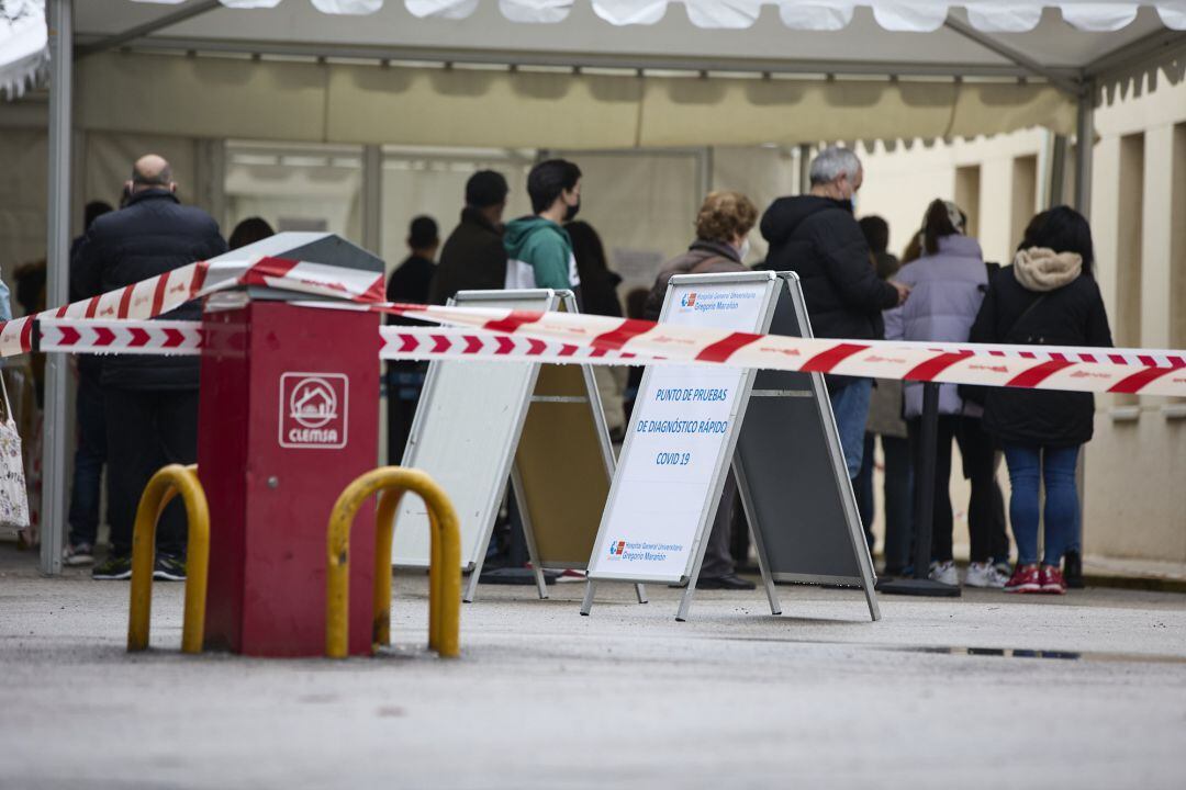 Varias personas esperan la cola en una carpa del Hospital Universitario Gregorio Marañón instalada para hacerse PCR