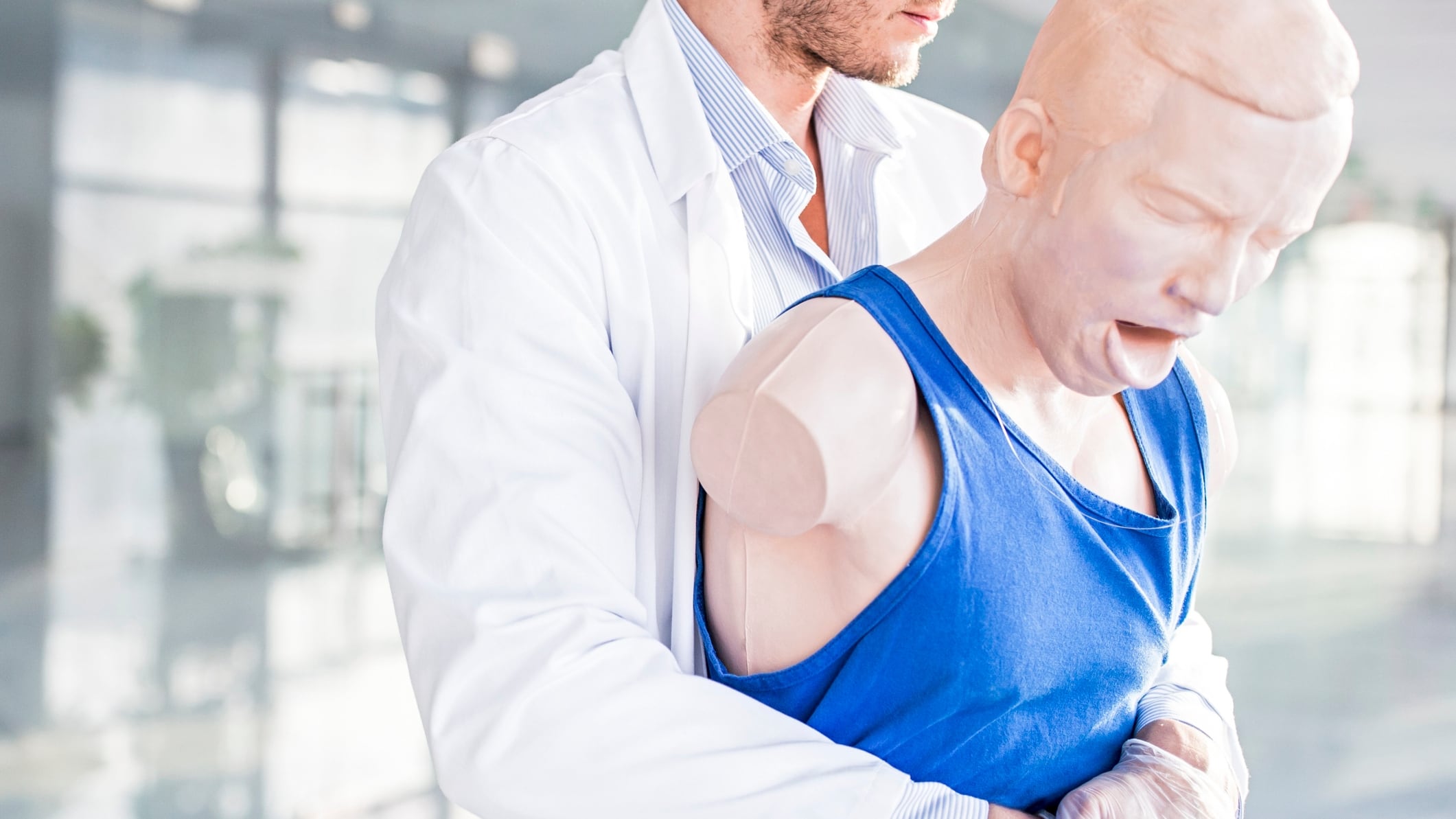 Doctor practising the Heimlich manoeuvre on a training dummy.