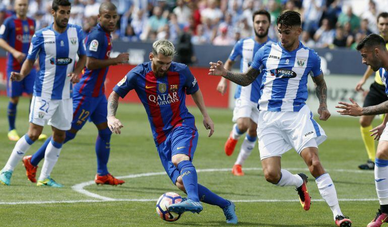 El jugador argentino del FC Barcelona Lionel Mess,iz., y Carl Medjani,d., del Leganés, durante el partido de La Liga que ambos equipos disputaron en el estadio de Butarque.