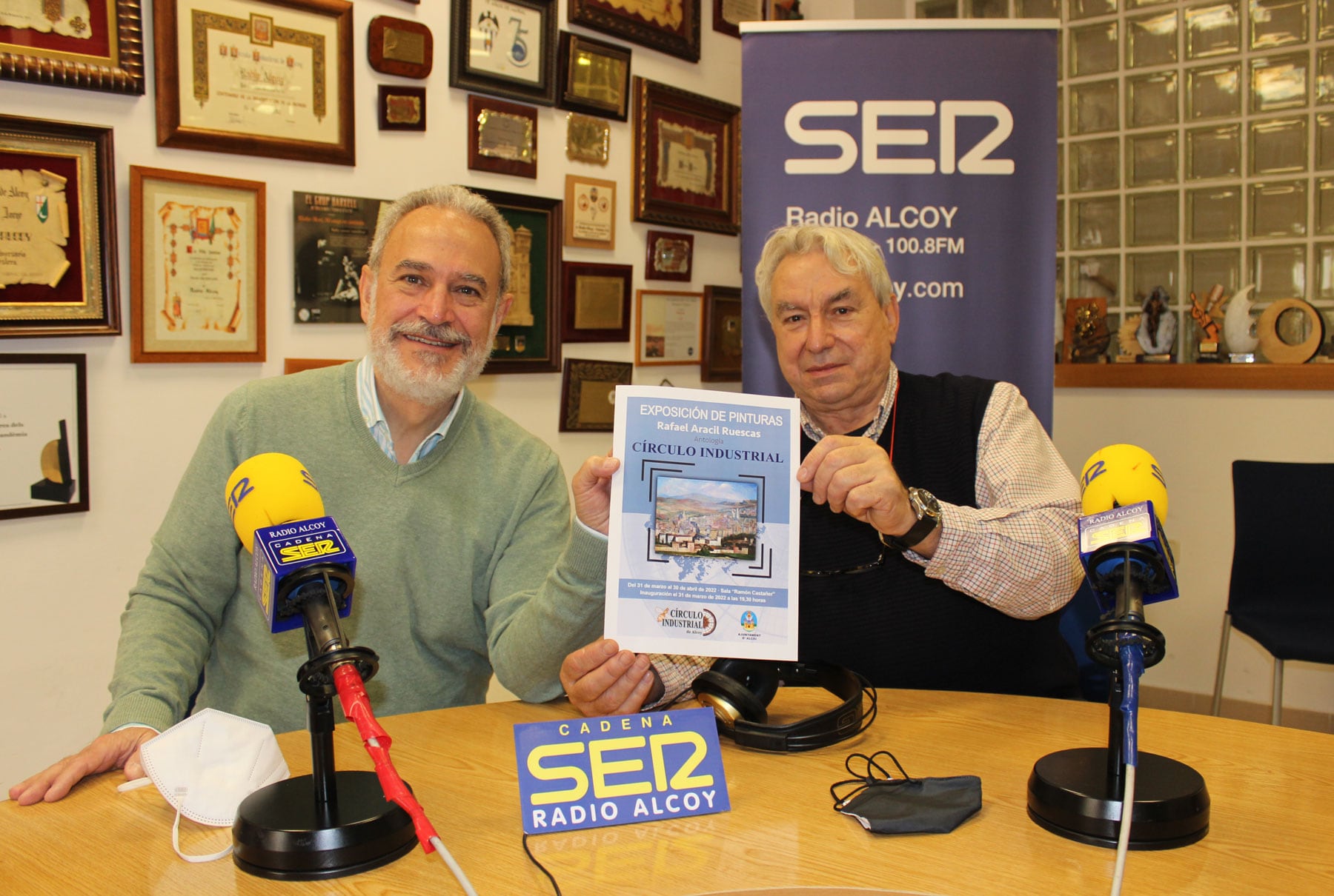 Indalecio Carbonell y José Luis Antequera muestran un cartel de la exposición