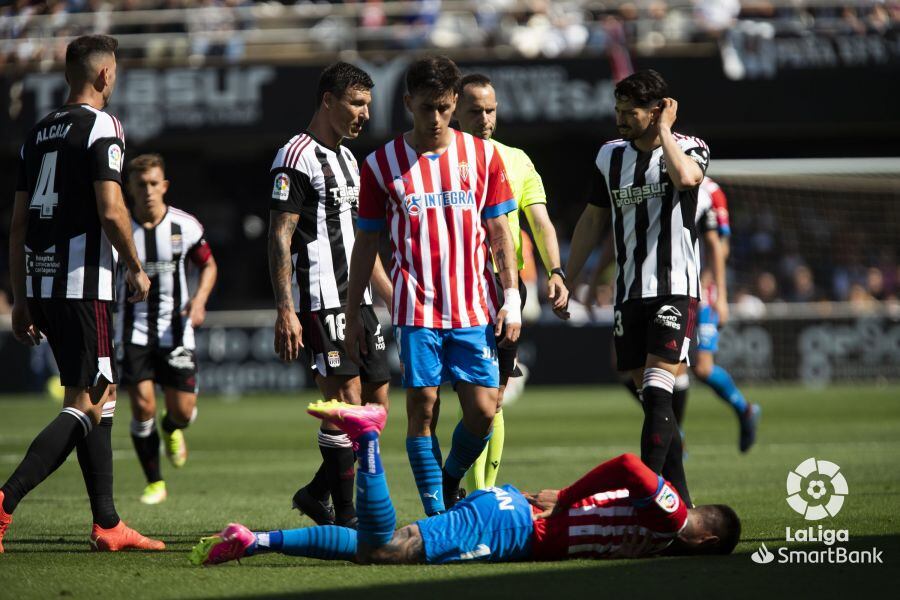 Un jugador del Sporting se lamenta en el césped de Cartagonova, bajo la mirada de Pedro Díaz.