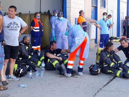 Varios bomberos son atendidos por personal sanitario en el incendio del polígono industrial de Marmolejo.