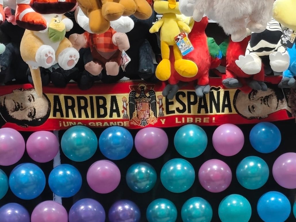 Imagen de uno de los puestos de la Feria de Murcia con una bufanda de la bandera de España con simbología franquista