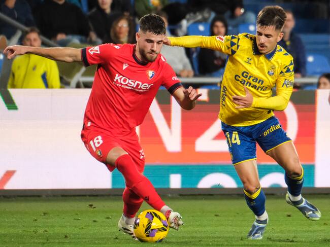 LAS PALMAS DE GRAN CANARIA, 24/01/2025.- El centrocampista de Osasuna Iker Muñoz (i) lucha con Manuel Fuster, de Las Palmas, durante el partido de LaLiga entre la UD Las Palmas y el Osasuna, este viernes en el estadio de Gran Canaria. EFE/ Angel Medina G.