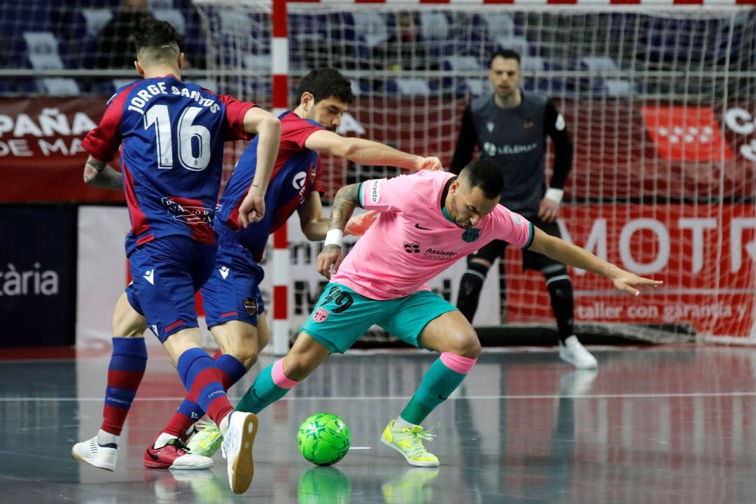 El pivot brasileño del Barça, Ximbinha, con el balón ante el jugador del Levante UD FS, Marc Tolrá
