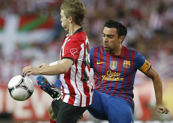 Iker Muniain pelea un balón con el ahora entrenador del FC Barcelona, Xavi Hernández