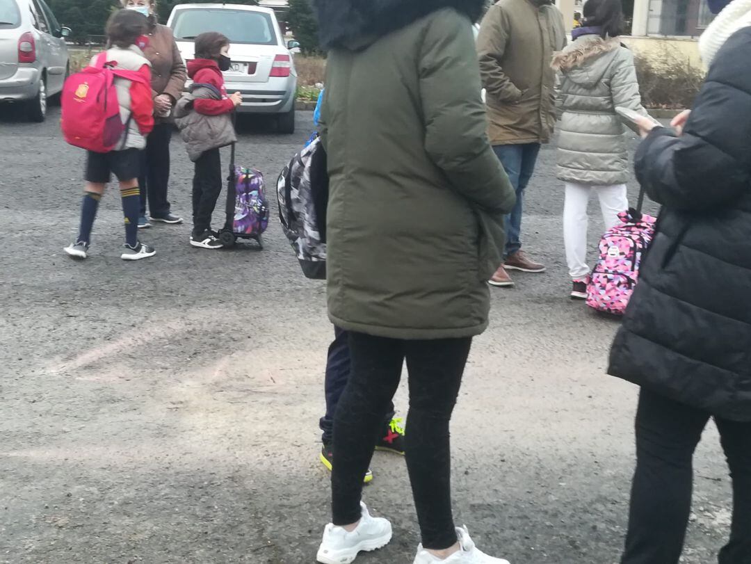 Familias esperando con sus hijos e hijas poder entrar al centro educativo, tras la reparación de la acometida