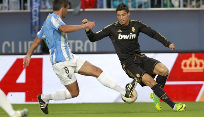 El jugador francés del Málaga C.F. Jérémy Toulalan intenta robarle la pelota al delantero portugués del Real Madrid Cristiano Ronald, durante el partido correspondiente a la novena jornada de la Liga de Primera