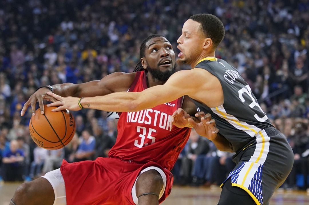 Kenneth Faried protege el balón ante la defensa de Stephen Curry.