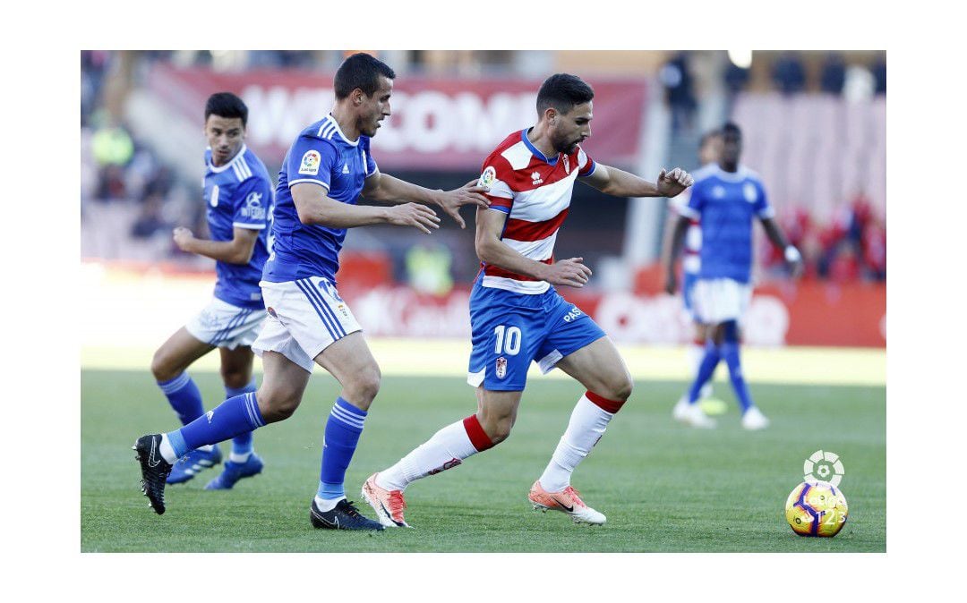 El jugador del Real Oviedo, Christian Fernández, presiona al futbolista del Granada Antonio Puertas.