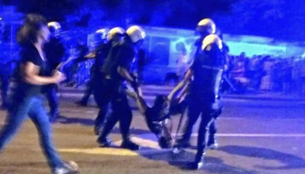 Agentes de la Policía Nacional se llevan a rastras a uno de los manifestantes