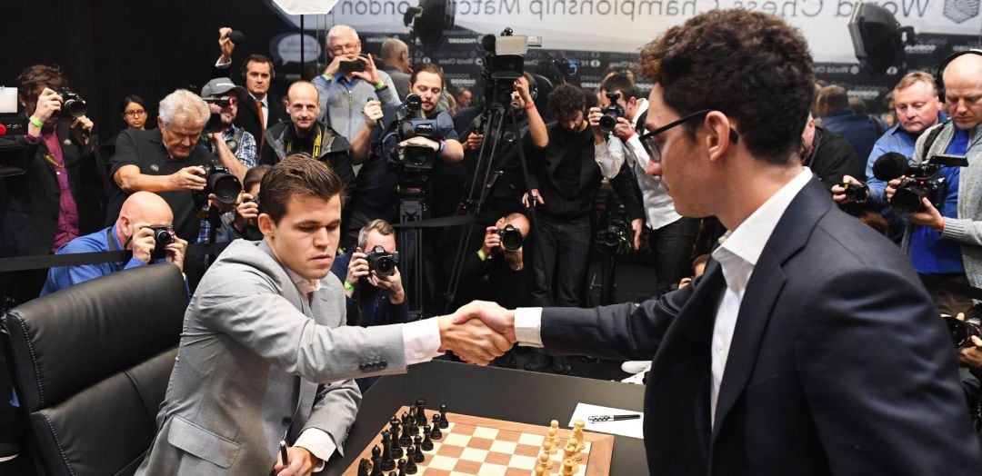 El noruego Magnus Carlsen, campeón mundial de ajedrez (i), saluda al aspirante al título, el estadounidense Fabiano Caruana (d), antes de comenzar la duodécima partida del Mundial de Ajedrez que se celebra en Londres