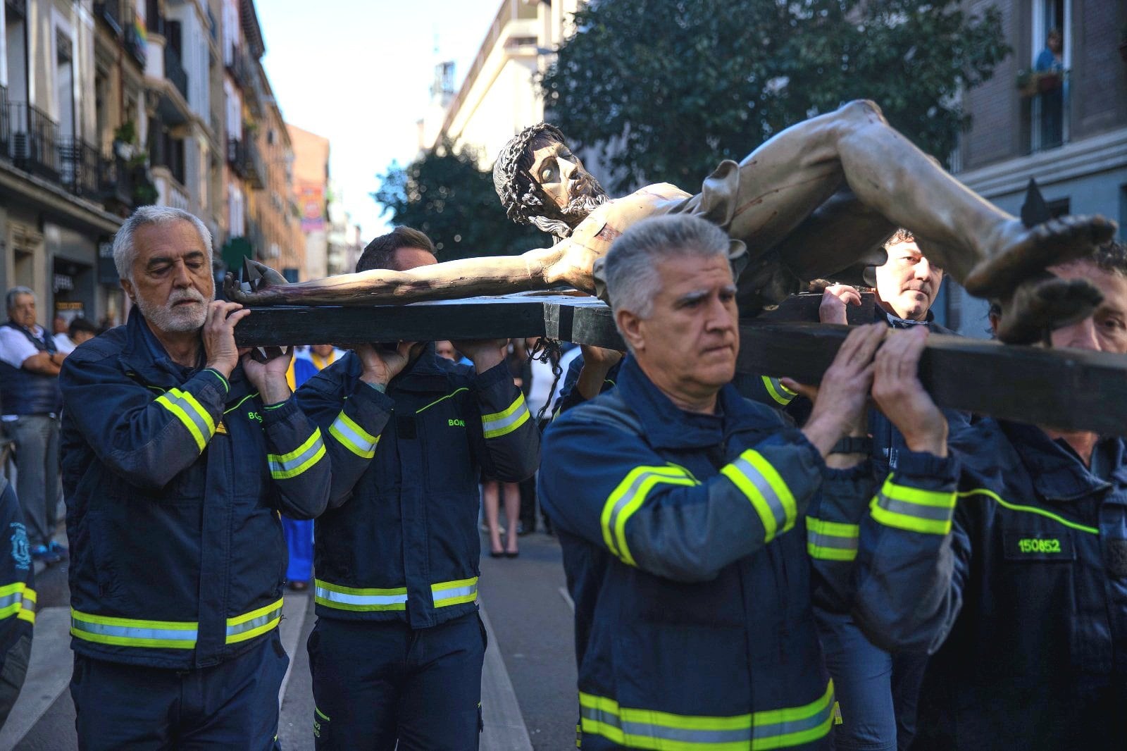 Bomberos del Ayuntamiento de Madrid en procesión, portando “El Cristo de los Niños”