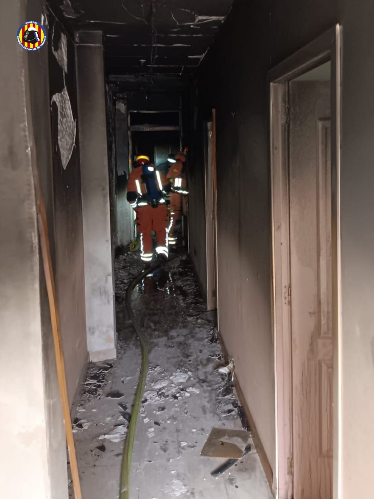 Los bomberos trabajando en la extinción del incendio de una vivienda en Burjassot (Valencia)