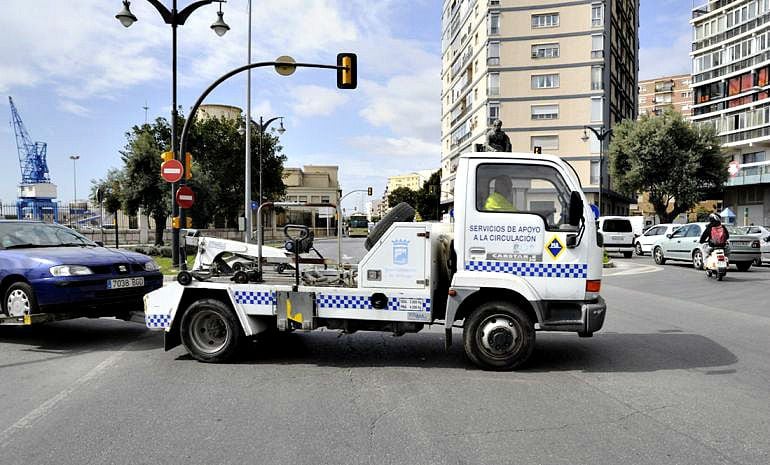 Imagen de la grúa municipal de Málaga llevándose un vehículo