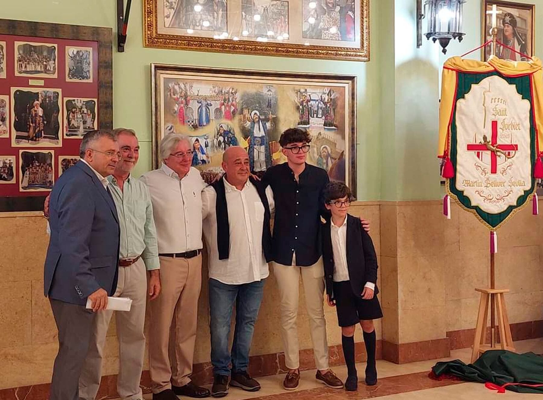 Martín Bellver Sevila, junto a sus predecesores de la filà en el cargo de Sant Jordiet, y el primer tro de los Miqueros, Rafa Verdú, cerca de la heráldica recién presentada