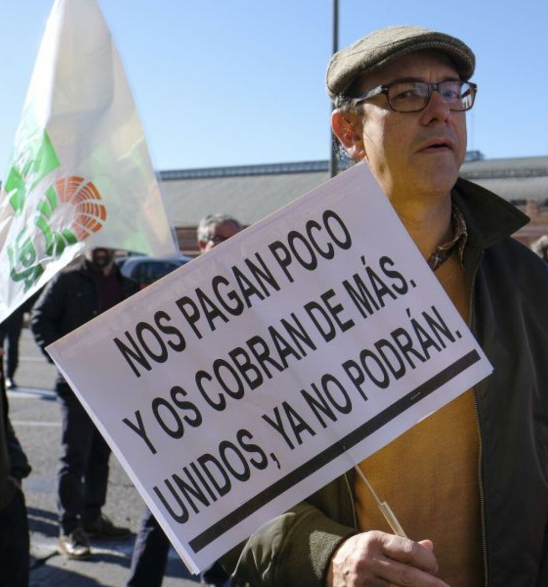 Un agricultor con una pancarta sobre los precios.