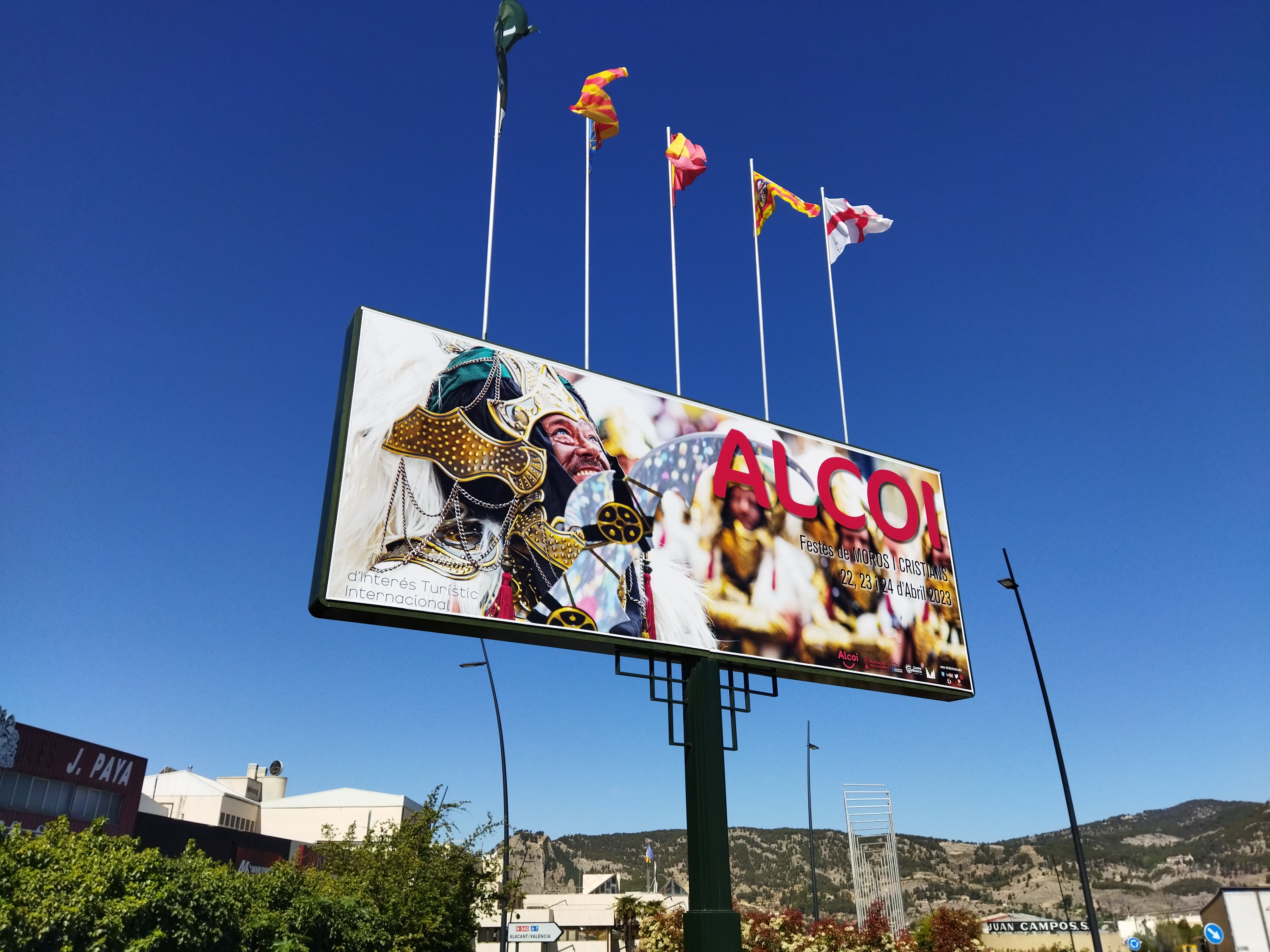 El cartel que anuncia las Fiestas de Moros y Cristianos en la entrada sur de Alcoy.