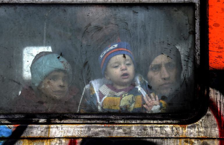 Un familia de refugiados mira a través de la ventana del tren antes de partir hacia a la frontera serbia, cerca de la ciudad de Gevgelija, Macedonia.