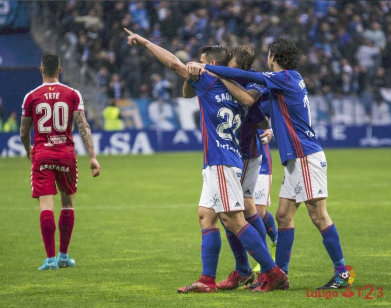 Saúl Berjón señala a la grada tras marcar el gol mientras es abrazado por sus compañeros.