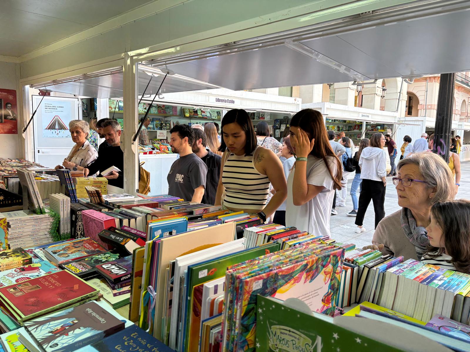 Oscenses de todas las edades, buscando ejemplares en la Feria del Libro de Huesca