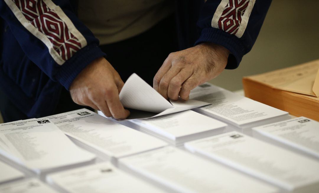 Una persona guarda su papeleta electoral en un sobre.