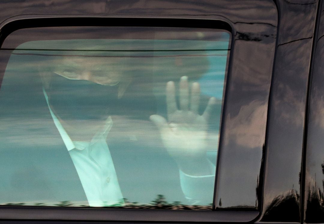 El presidente Donald Trump, saluda desde el coche. 