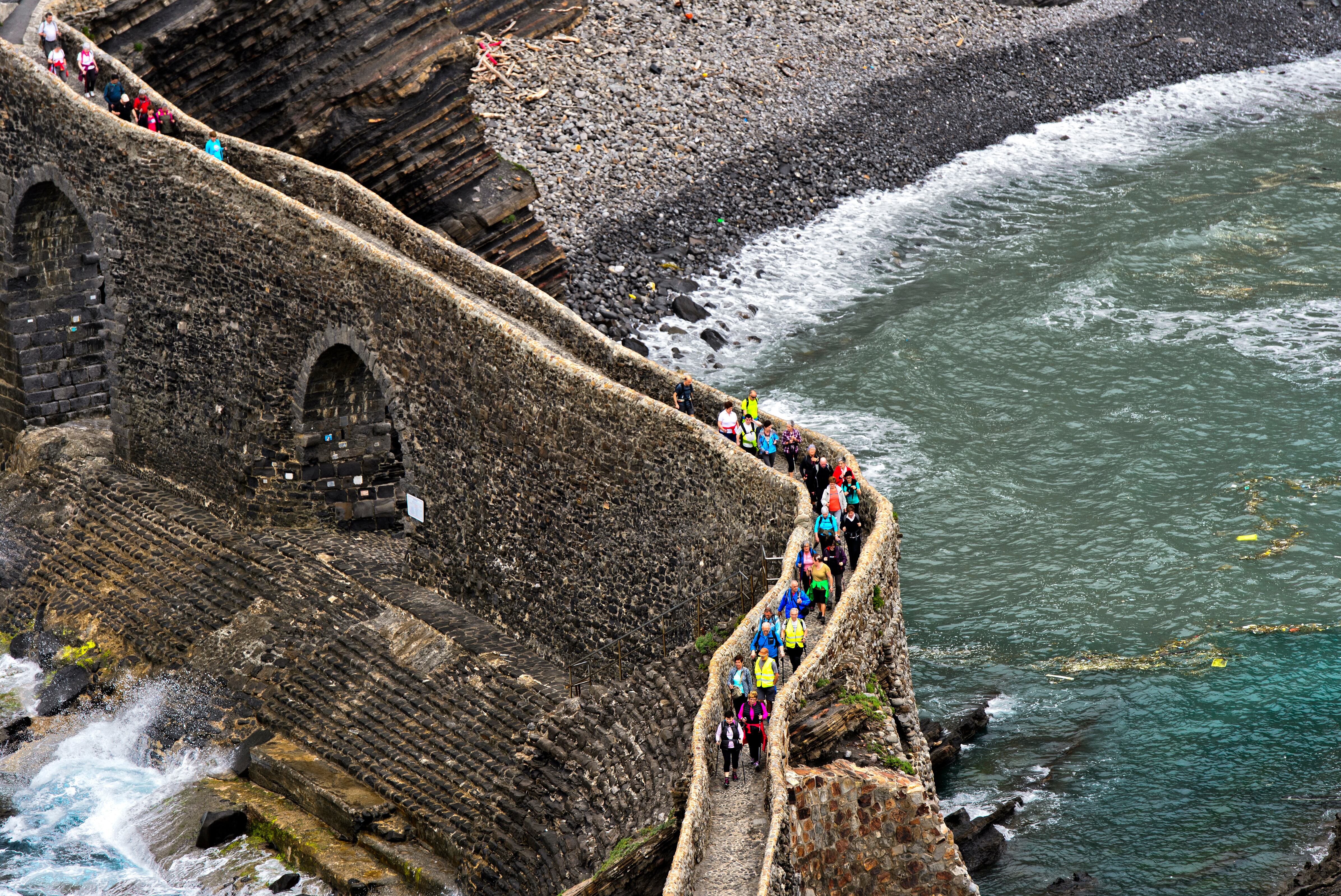 Visitors crossing the stone bridge to the islet Gaztelugatxe near Bakio, Costa Vasca, Bay of Biscay, Basque Country, Spanien. (Photo by: Gunter Fischer/Education Images/Universal Images Group via Getty Images)