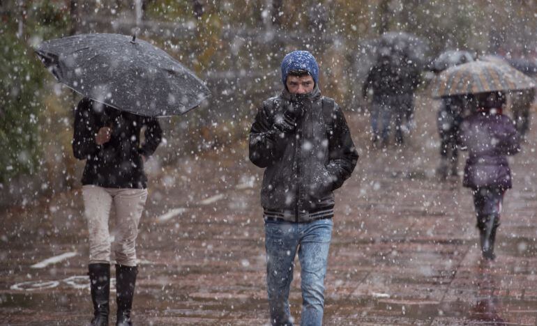  - Esta mañana ha comenzado el primer temporal de nieve en Vitoria. En la imagen, un joven intenta protegerse de esta nevada por las calles de Vitoria. EFE. ADRIÁN RUIZ DE HIERRO