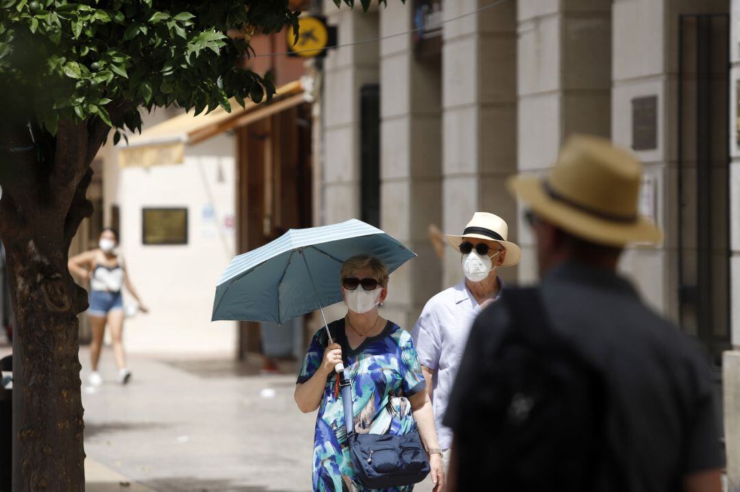 Varias personas intentan protegerse del calor.