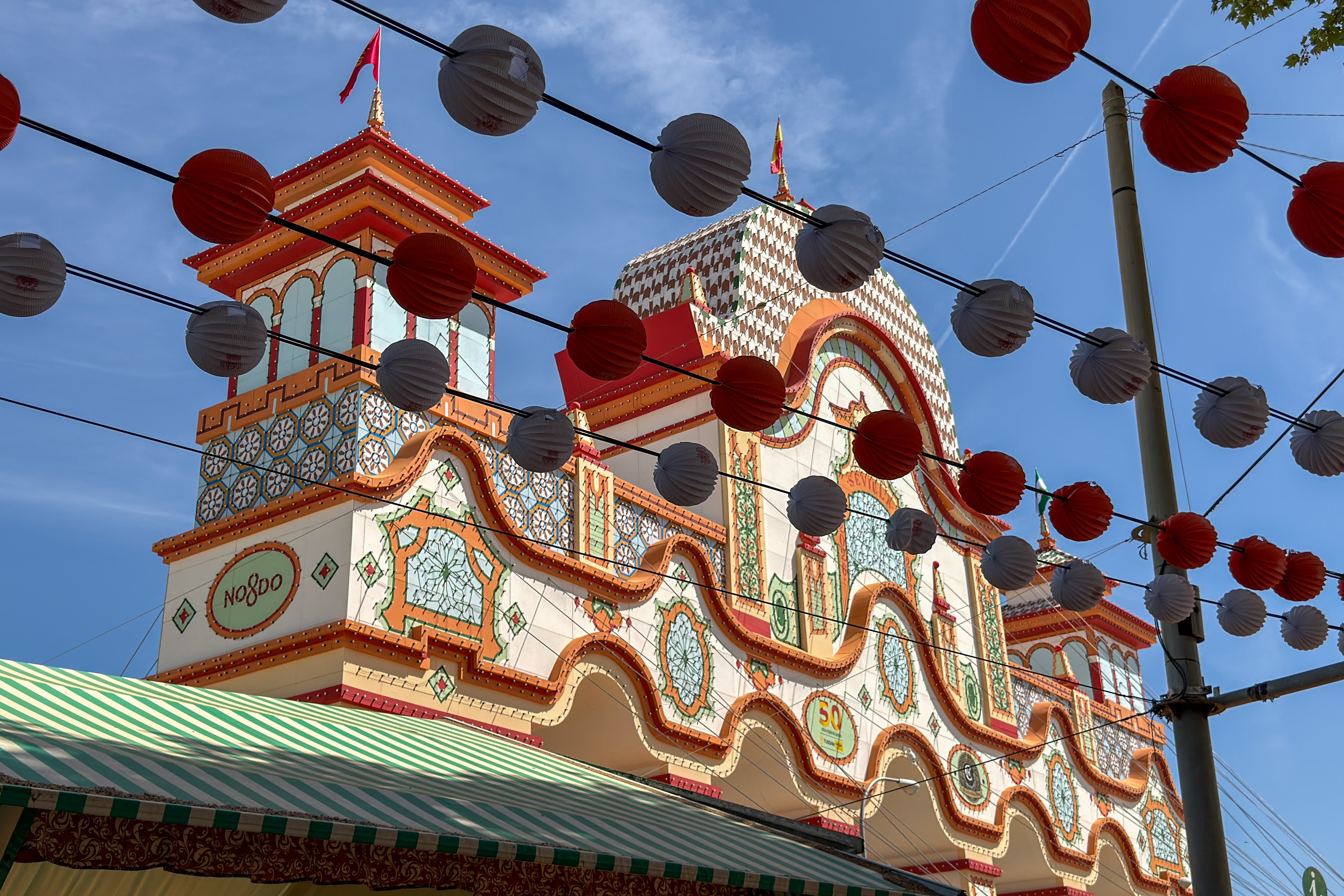 SEVILLA (ESPAÑA), 19/04/2026.- Vista de la decoración de unos farolillos mientras se dan los últimos retoques en el Real de la Feria, para que mañana a las 00:00 cuando se produzca el encendido del tradicional alumbrao dé comienzo la Feria de Abril de este 2026. En una semana que se presume que será muy calurosa, todo se pone apunto para que mañana esté perfecto. Se termina de pintar las casetas, se preparan las mesas para la cena del Pescaito, se limpian los adornos y se rellenan las neveras para que no falte de nada. EFE/ David Arjona