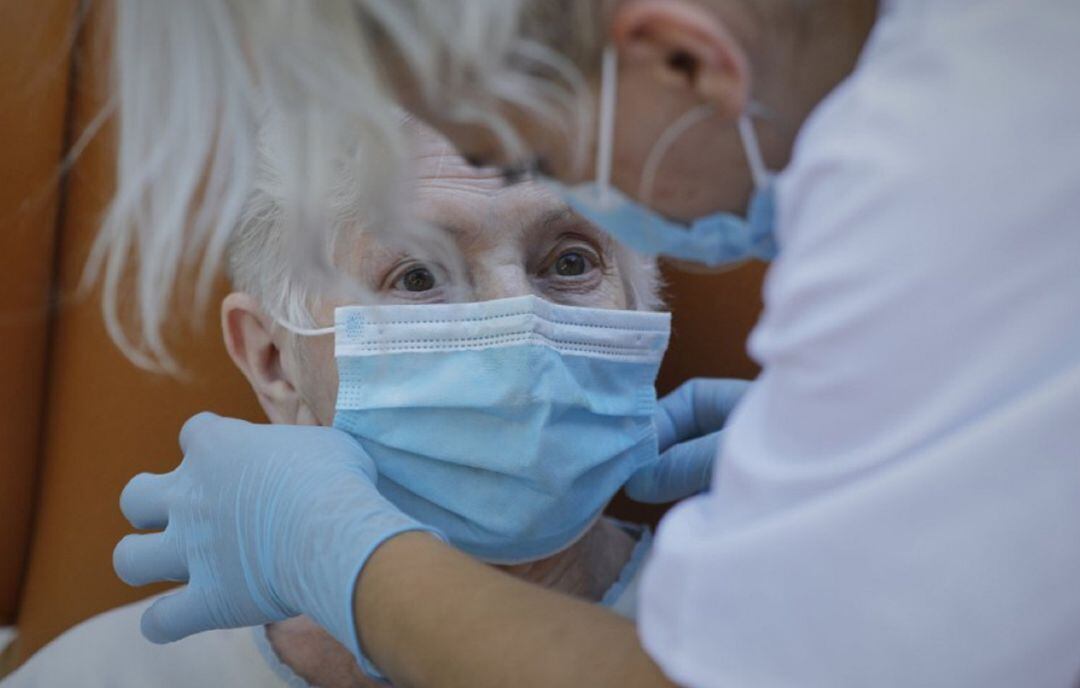 Colocando la mascarilla a una anciana