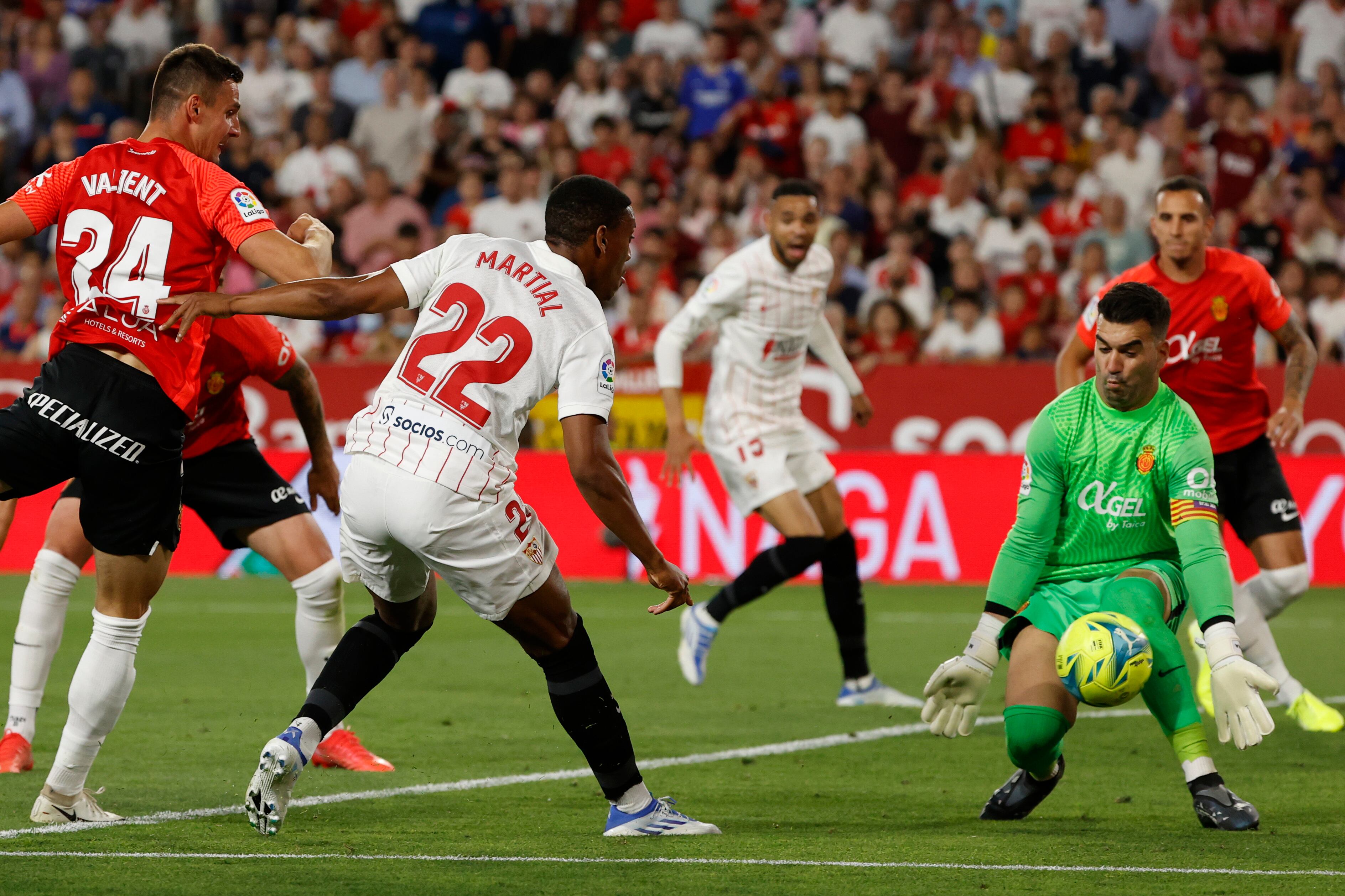 SEVILLA, 11/05/2022.- El portero del Mallorca, Manolo Reina (d), detiene el remate de Anthony Martial (c), del Sevilla, durante el partido de Liga en Primera División que disputan hoy miércoles en el estadio Ramón Sánchez-Pizjuán. EFE/Julio Muñoz