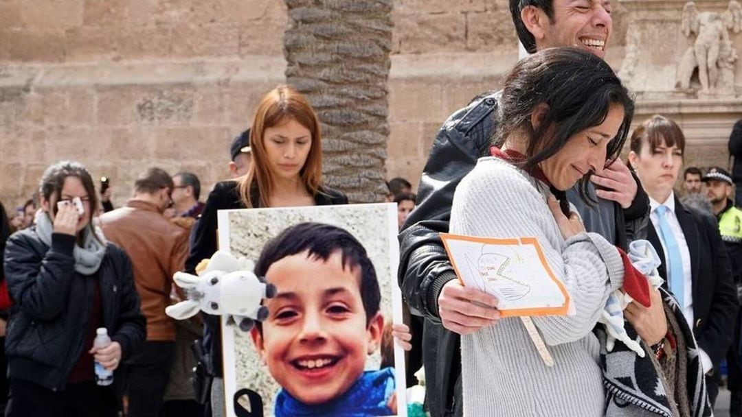 Los padres del niño Gabriel Cruz junto a una foto del pequeño en una concentración