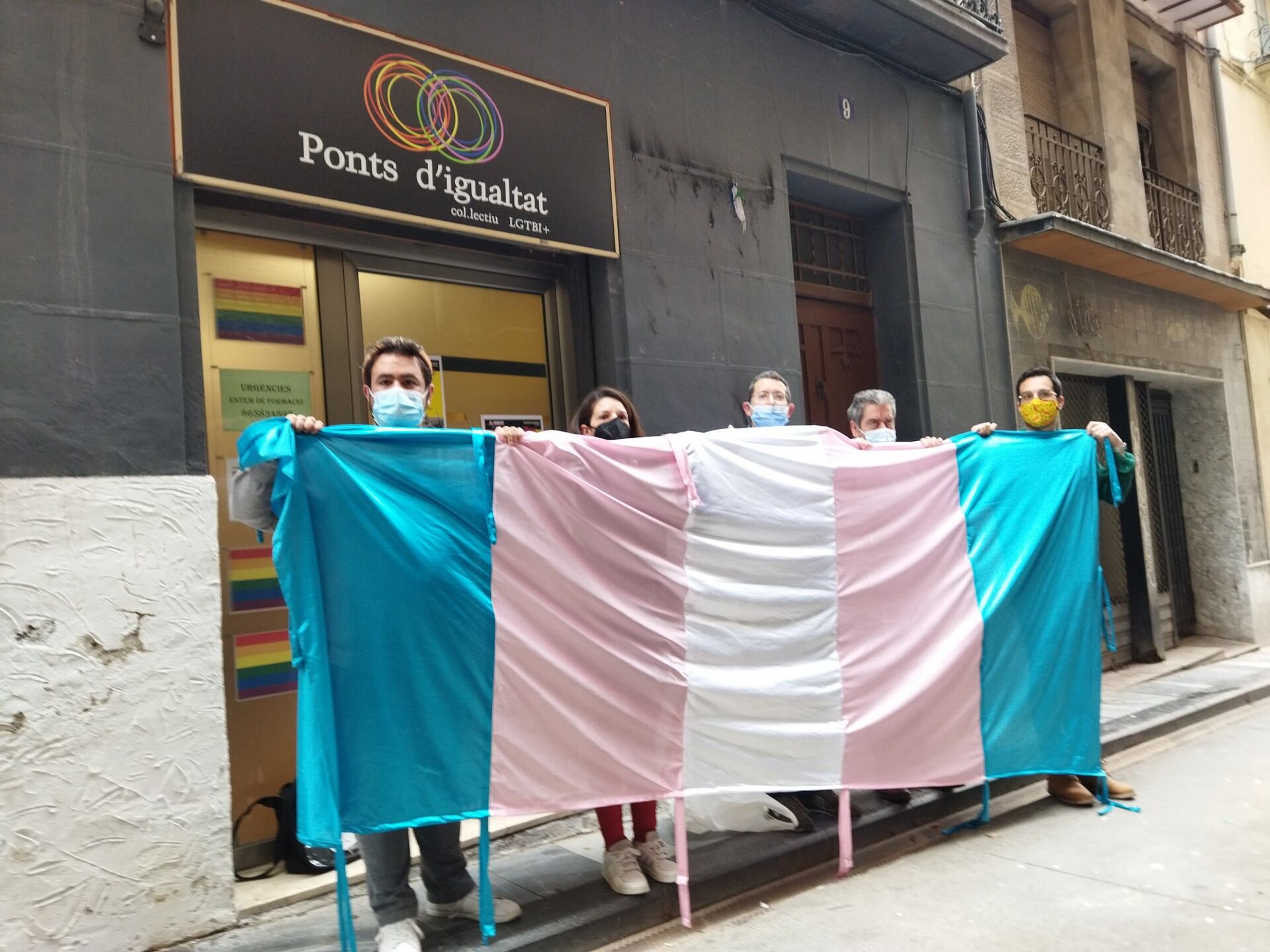 Componentes de Ponts d'Igualtat muestran la bandera que no les dejan colocar en el balcón del Ayuntmiento y piden un espacio alternativo.