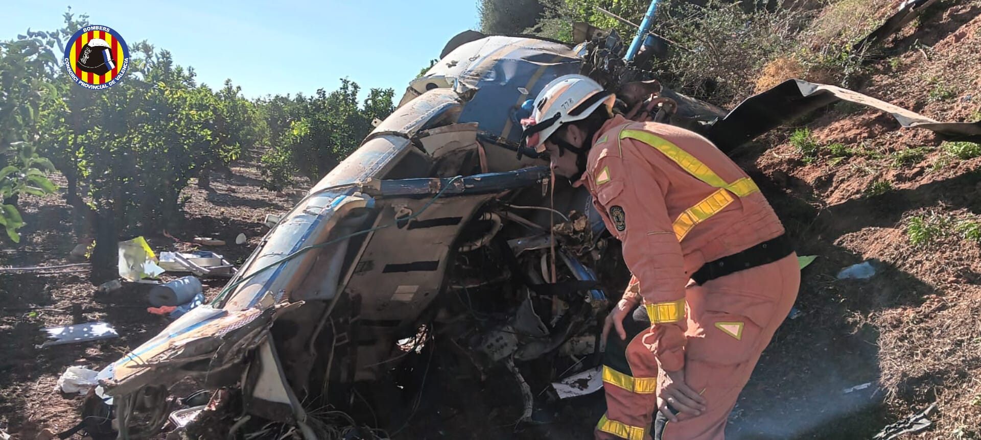 Bombero inspecciona el helicóptero accidentado en el municipio de Puçol (Valencia), donde han fallecido tres personas