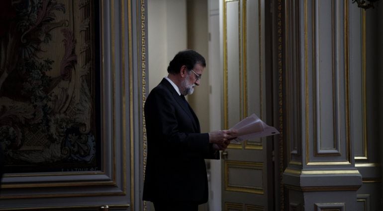 El presidente del Gobierno español, Mariano Rajoy, lee unas notas antes de participar en una rueda de prensa