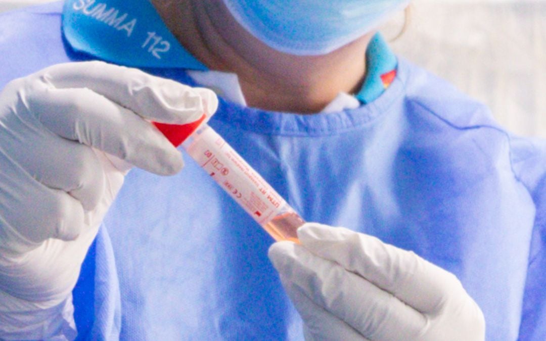 Un trabajador sanitario protegido sostiene una de las probetas utilizadas para la realización de tests PCR en el Centro de Especialidades Carabanchel Alto