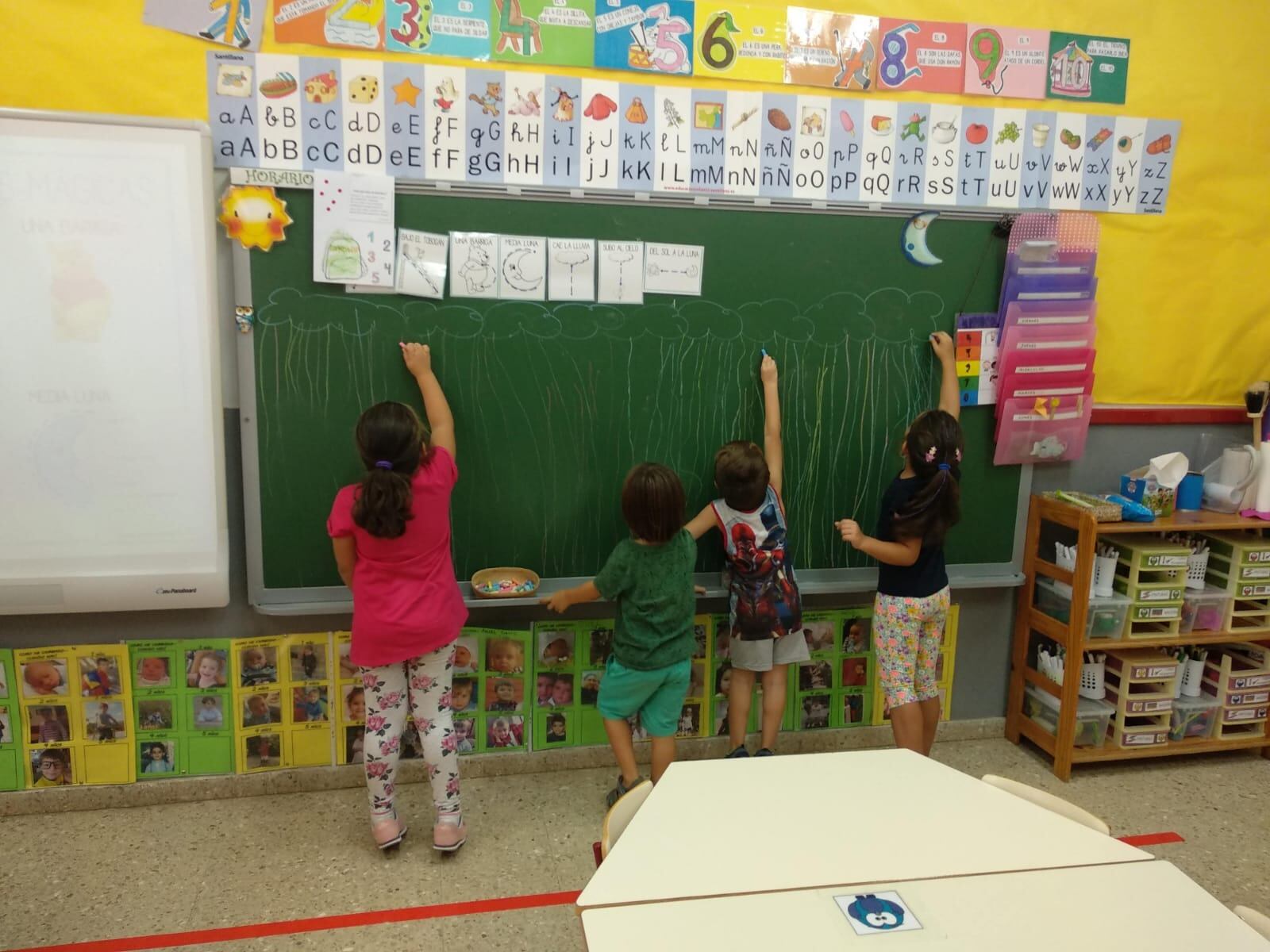 Unos alumnos escriben en la pizarra de un centro educativo