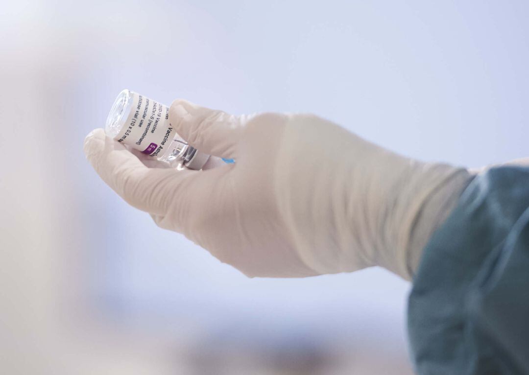 Una profesional sanitaria sostiene un vial con la vacuna.