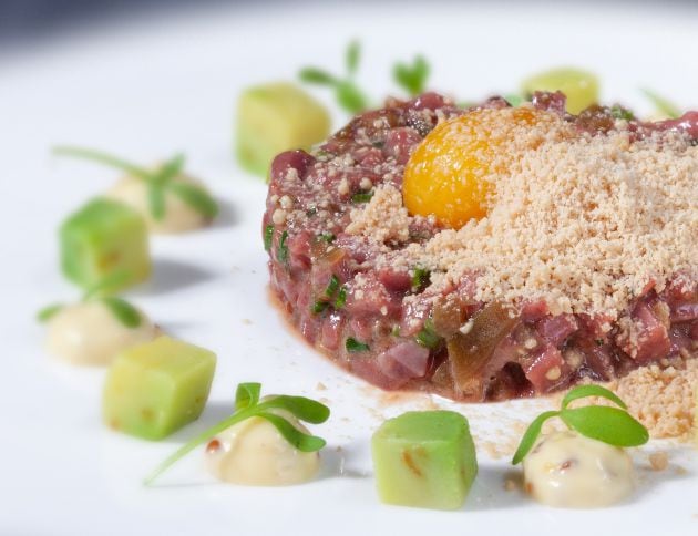 Tartar de corozanes de cordero con pepinillos, cebolleta blanc, jengibre, ajos tiernos, polvo helado de &#039;foie-gras&#039;, mahonesa de mostaza, aguacate y yema de huevo.